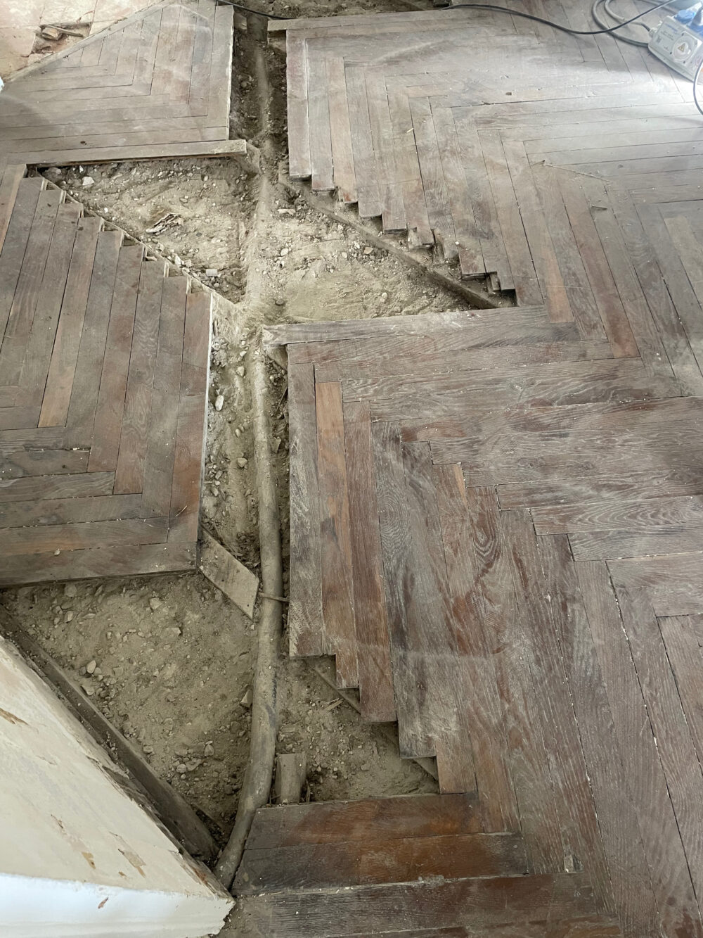 Parquet ancien avant rénovation appartement Lyon Remplacement d'une évacuation en plomb sous un parquet ancien à Lyon 6e